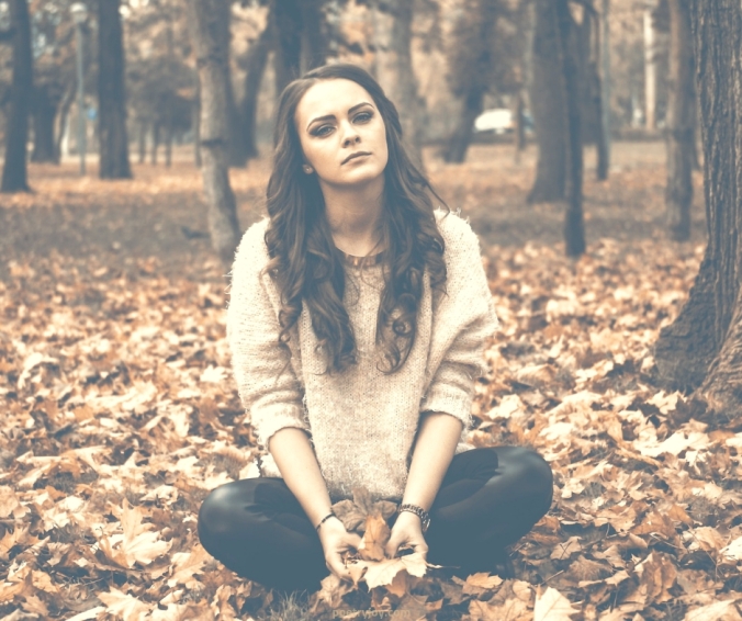 complete: God has the answer to our brokenness and pain - girl sitting with dried autumn leaves 